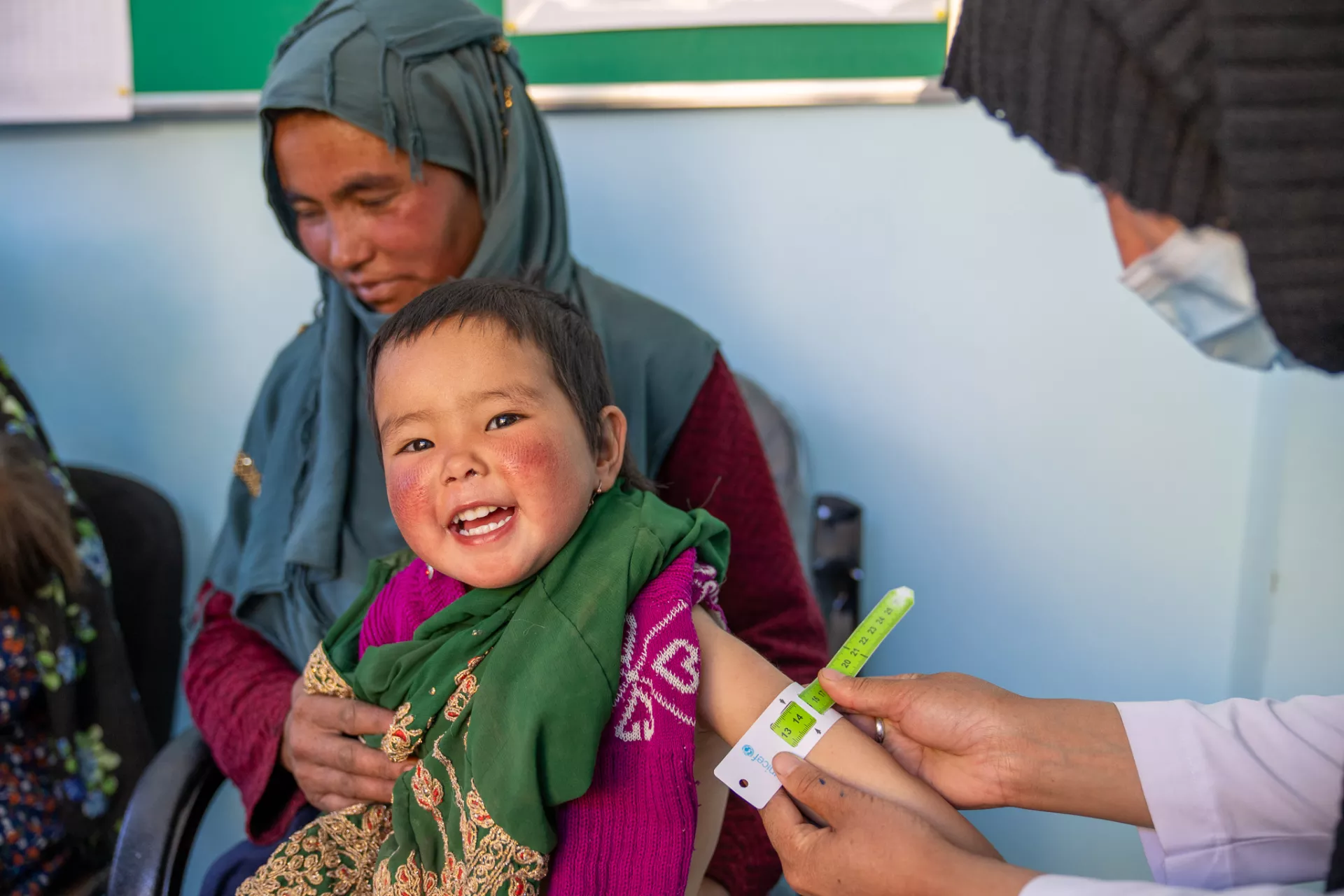 A 3-year-old has her mid-upper arm circumference measured to screen her for signs of malnutrition in Afghanistan
