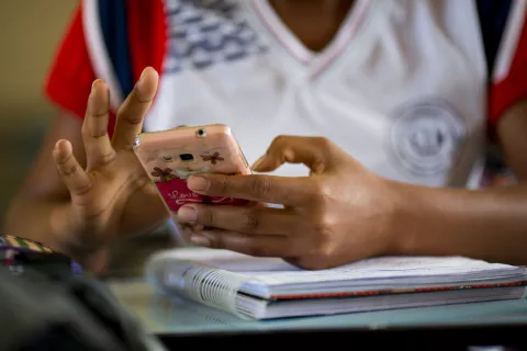 An adolescent uses a mobile phone
