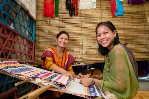 Two adolescent girls at a weaving class