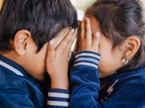 Children covering their eyes with their hands