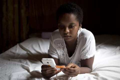 An adolescent girl looks at a smartphone