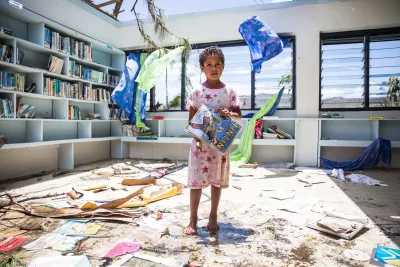 Makelesi, 7, standing in destoryed library of Nabau District School in Ra Province, Fiji after a cyclone