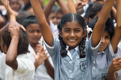 Girl in Fijian school raises her arm