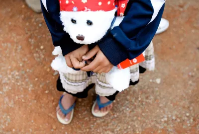 A girl who is HIV-positive holds a teddy bear in Ruili City, Yunnan Province. 
