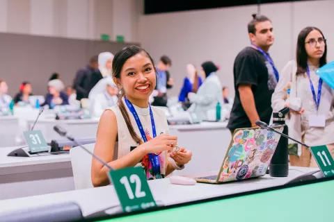 Nikka smiling at the camera while attending a conference