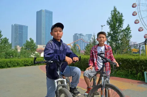 two children are riding bicycle