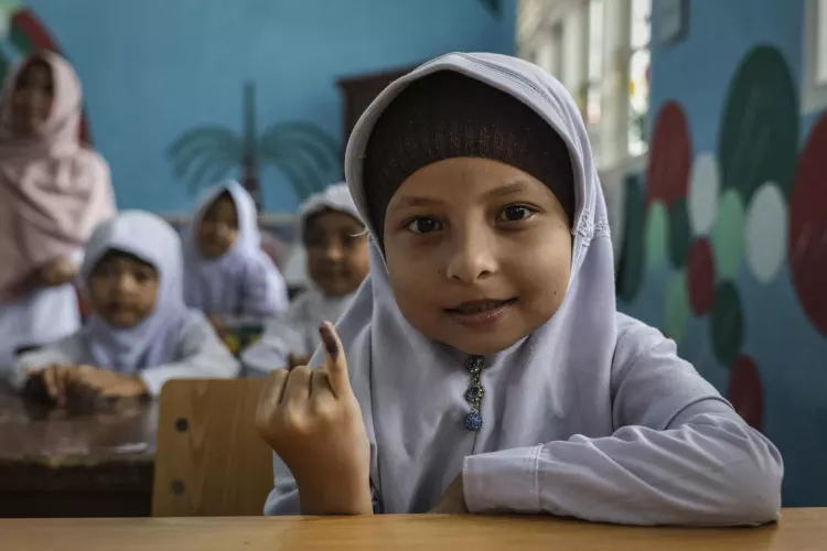 Halimatun Sakdiah, 7, shows her marked finger after receiving the polio vaccine at Rantau Primary School during a polio immunization campaign in Aceh Province, Indonesia.