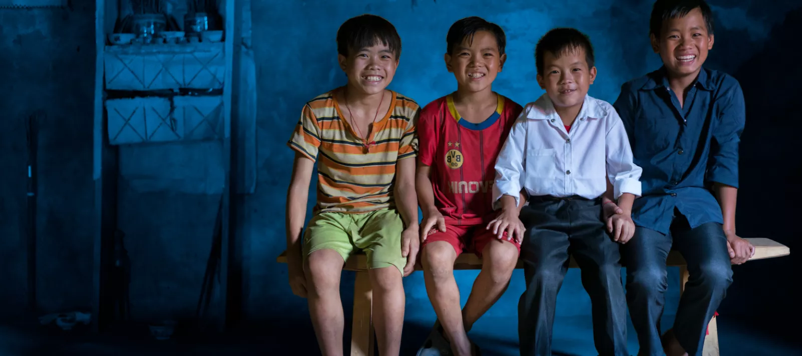 four boys sit on a bench in Viet Nam