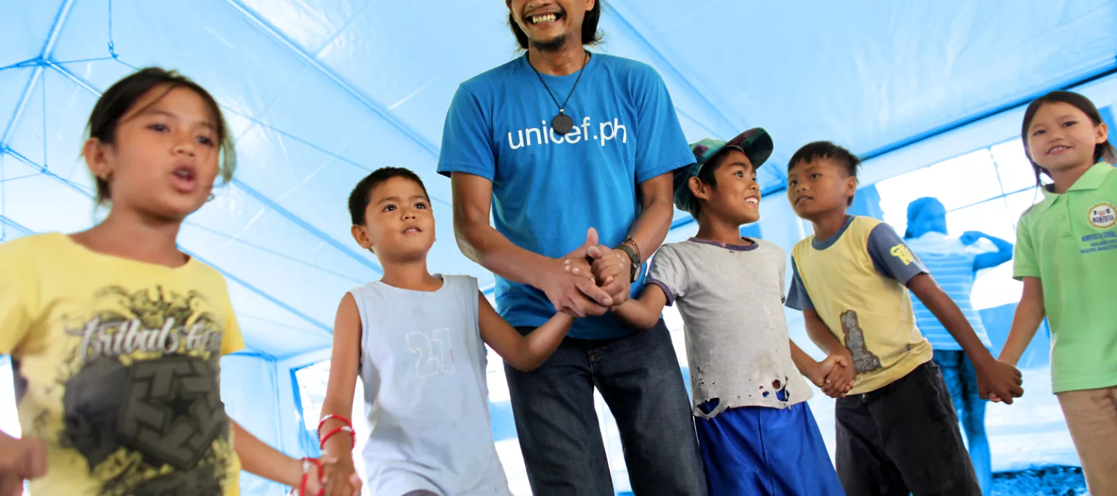 a UNICEF worker plays with children at a child-friendly space