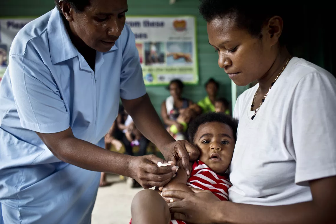 A health worker vaccinates a child against measles, mumps and rubella (MMR) at the 9 Mile Health Clinic outside Port Moresby, Papua New Guinea