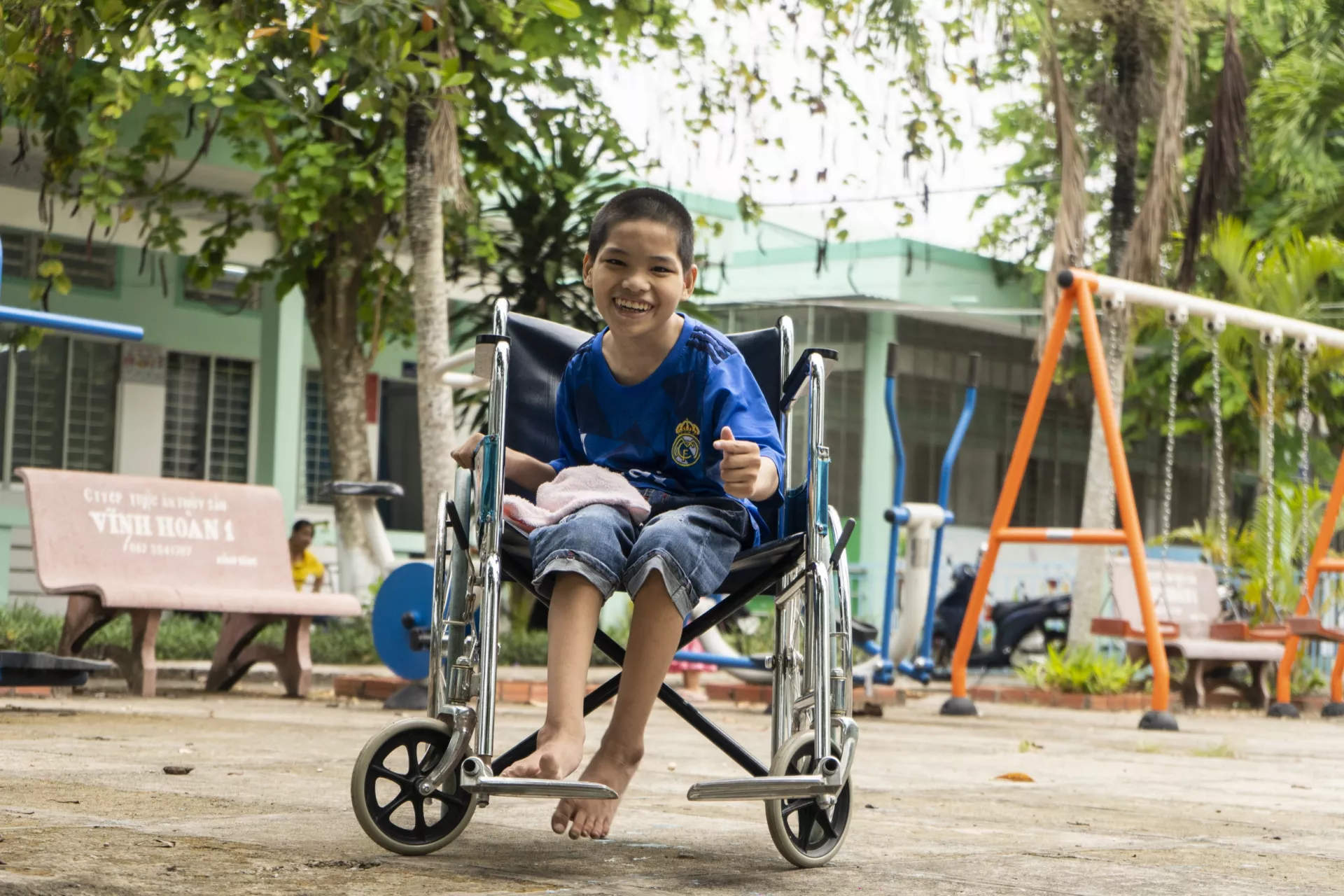 A boy smiles from his seat in a wheelchair