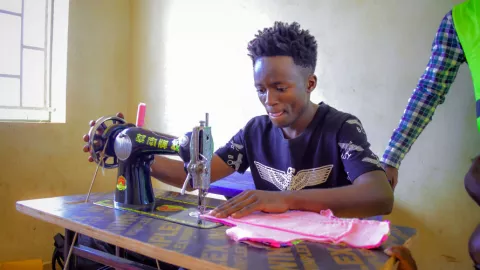A adolescent working at a sewing machine