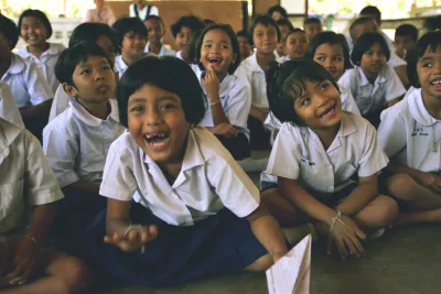 Children in school sitting down smiling, laughing