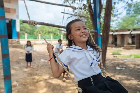 Happy children play on a swing set at Hun Sen Ta Vaeng Primary School in Ta Vaeng Village, Ta Vaeng Leu Commune, Ta Vaeng District, Ratanakiri Province.