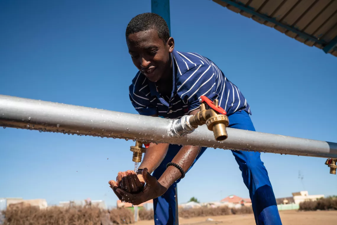Suaafi Mahamed Abdi, 15, cleans his hands at an EU-funded, UNICEF-supported water point in Tog-wajaale, Somaliland.