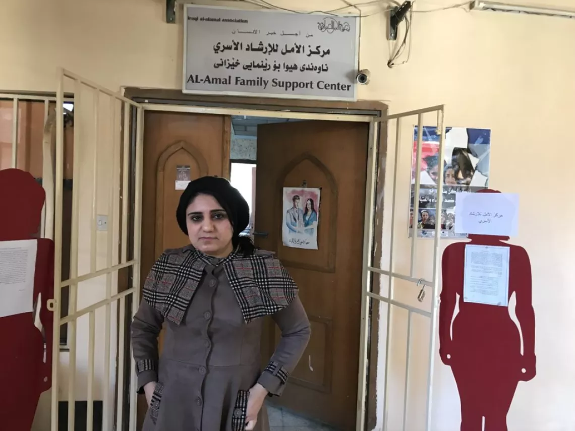 «كيي عبد الستار» أمام مركز الأمل للإرشاد الأسري. ولديها صور معروضة في المركز لنشطاء عرب وعراقيين مشهورين لتكون مصدر إلهام للنساء اللواتي يحصلن على الخدمات هناك.