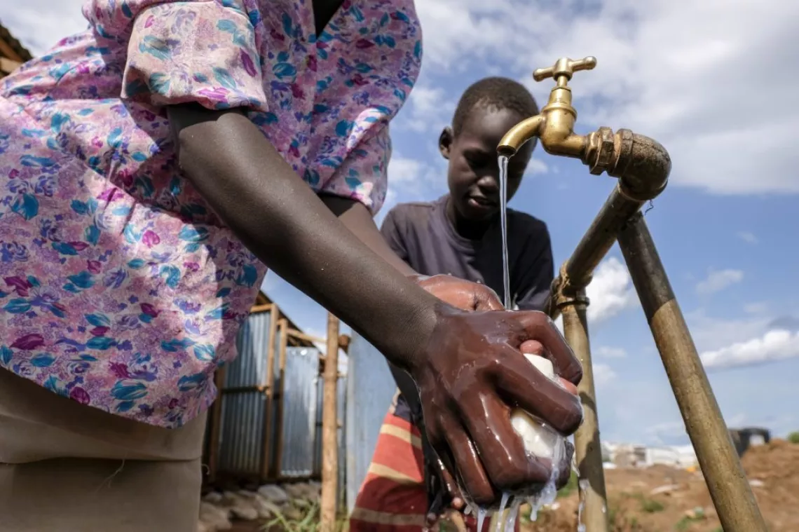 12岁的尼亚姆在朱巴平民保护所的水龙头下洗手。