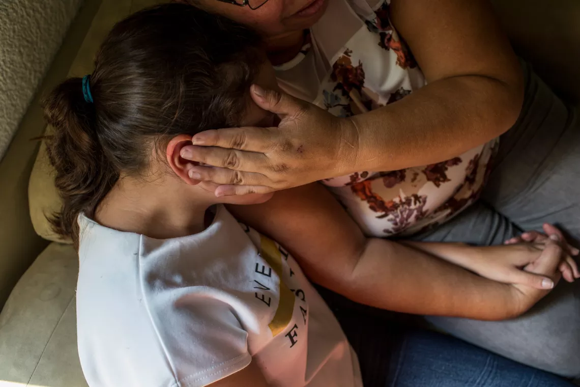 在位于萨尔瓦多的家中，17岁的黛安娜（化名）蜷缩在妈妈怀中，紧握着妈妈的手。在经历了来自男朋友的网络凌辱后，黛安娜删除了自己的社交媒体账号。如今的她是保护网络安全的坚定倡导者。
